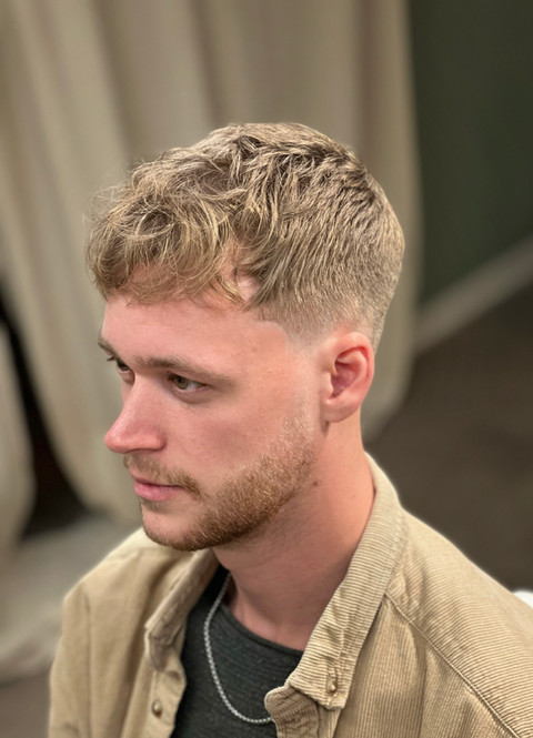 Fade haircut with wavy fringe.