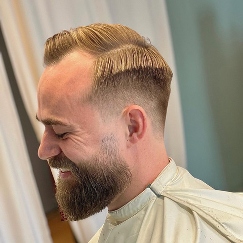 Low fade haircut with side part and beard trim. Barbershop Østerbro.